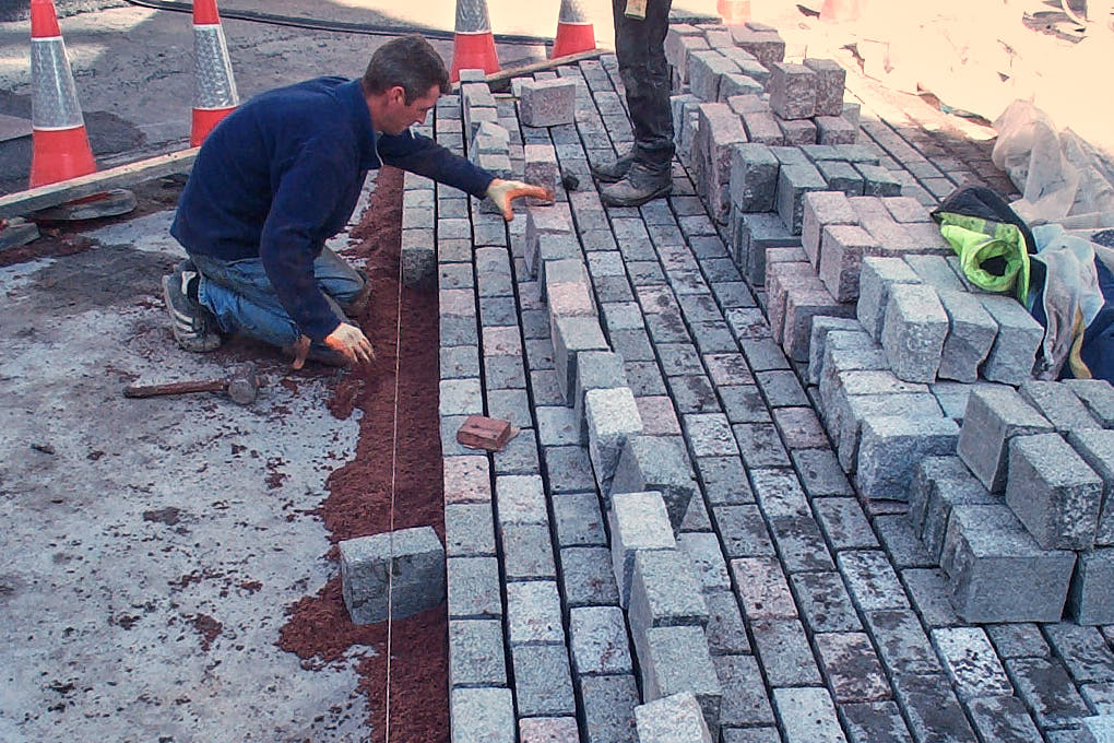 Man laying block paving