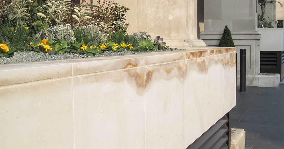 Staining of building stone used to clad a building