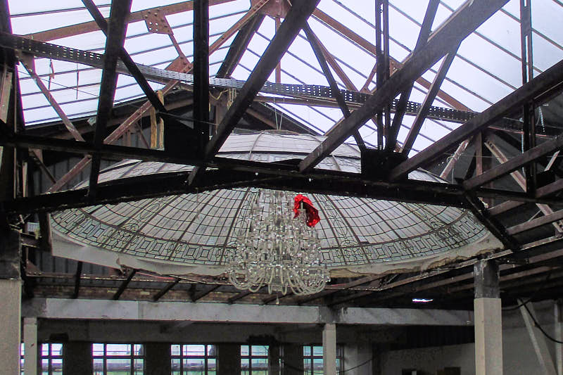 An empty building with a glazed roof and exposed trusses undergoing refurbishment